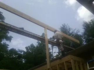 Carpenter setting a ridge beam over a new addition frame — Ice Dam Removal by Roofing Brothers in Midvale